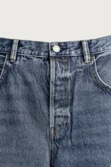 Jeans baggy fit de tiro medio, confeccionados en denim de algodón con efecto lavado. Presentan un diseño de cinco bolsillos, corte holgado y amplio en toda la pierna, con cierre frontal de botones.