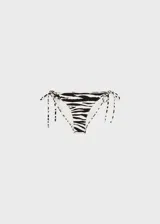 Traje de baño de dos piezas con estampado de cebra en blanco y negro. El corpiño es strapless con forma de corazón y la bombacha es de corte clásico con lazos laterales.