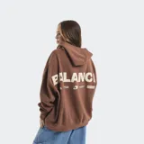 Buzo tipo hoodie color marrón, de corte oversize, con capucha, bolsillo frontal tipo canguro y estampado minimalista en el centro del bolsillo.