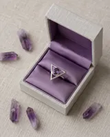 Anillo de plata 925 con diseño geométrico triangular y piedra amatista central de corte ovalado.