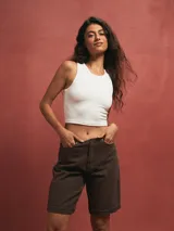 Short de jean color gris oscuro, tiro alto, con dobladillo ancho en el ruedo y corte recto que llega por encima de la rodilla.