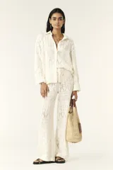 Camisa color blanco hueso con cuello clásico, tapeta con botones en la parte delantera y corte recto ligeramente oversize. Diseño con acabado de encaje.