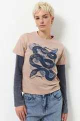 Remera negra de algodón, de manga corta y con estampa de serpiente doble y desgastada en color gris.