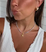 Collar corto de cristalitos facetados en tonos pasteles, con dije colgante de estrella de mar y cierre de acero.