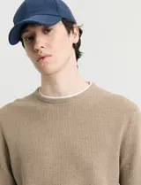Sweater de punto con textura waffle, color negro, de corte clásico con cuello redondo y mangas largas con puños ajustados.