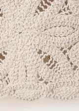Chaqueta de punto grueso color beige con diseño de encaje en relieve, cuello redondo y cierre frontal.
