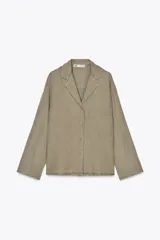 Camisa color verde oliva confeccionada en lino 100%, de corte recto, con cuello solapa, escote pico, manga larga con puños abotonados y cierre frontal con botones.