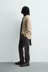 Jersey de punto con textura acanalada y diseño jaspeado en tonos beige y amarillo. Presenta un corte relajado, cuello redondo y mangas largas con acabados en rib.