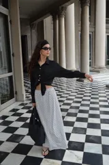 Pollera larga de viscosa, color azul marino con estampado de lunares blancos. Diseño de tiro alto y corte amplio.