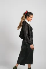 Falda larga de cuero ovino negro, de corte ligeramente acampanado, con costuras verticales visibles.