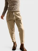Pantalón tipo babucha de corte holgado, color negro, con cintura elastizada y cordón ajustable. Presenta pinzas delanteras, bolsillos laterales y terminación con dobladillo en los tobillos.