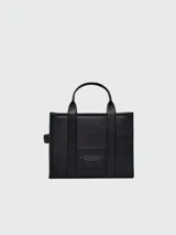 Cartera tipo tote de Marc Jacobs, confeccionada en cuero granulado color beige. Presenta el logo 'THE TOTE BAG' estampado en el frente, doble asa superior y correa de hombro ajustable y extraíble.