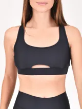 Top deportivo negro con breteles anchos y abertura en el centro del pecho.