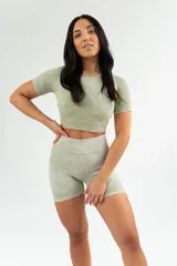 Conjunto deportivo color verde oliva, compuesto por un top corto de mangas cortas y un short ajustado de tiro alto.