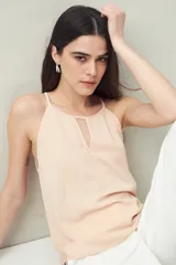 Top blanco de textura arrugada, con cuello halter y un corte en V profundo en el escote.