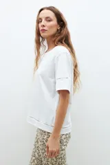 Remera blanca de algodón con mangas cortas y detalle de vainillas en los bordes.