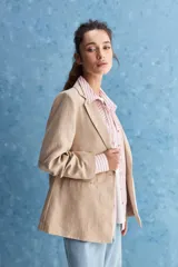Blazer de corte sastrero con silueta relajada, solapas tradicionales, cierre frontal de un botón y bolsillos de vivo.