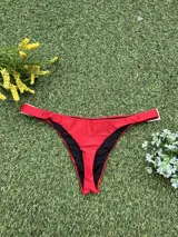 Conjunto de bikini rojo con hebillas metálicas plateadas y bombacha colaless.