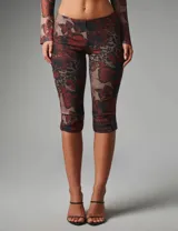 Conjunto de dos piezas de mesh elastizado con estampado floral y animal print, compuesto por un top corto de manga larga con cierre frontal de botones y abertura tipo lágrima, y un pantalón capri de tiro medio y calce ajustado.