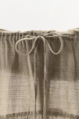 Pantalón de tiro medio confeccionado en mezcla de lino, con pernera recta, textura estructurada y detalle de tejido en superposición en la cintura.