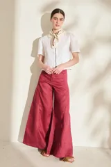 Pantalón de lino blanco de corte wide leg, con diseño amplio y costuras pespunteadas a contratono.