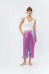 Pantalón de lino con acabado metalizado tornasolado, que refleja tonos entre rosa y lila según la luz. De corte recto y largo ¾, tiene cintura con elástico en la espalda que aporta comodidad y un calce relajado.