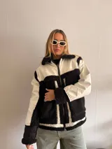 Campera con cuerpo de corderito negro y detalles en blanco.