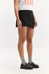 Short pollera sastrero con frente cruzado asimétrico y líneas limpias, confeccionado en algodón.