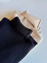 Pack de dos poleras de cuello alto confeccionadas en tejido de punto acanalado. El set incluye una unidad en color negro y otra en color beige, ambas con diseño ajustado al cuerpo y manga larga.