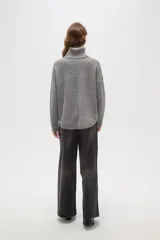 Polera de tejido de punto con cuello alto, diseño holgado y mangas largas. Presenta una textura de relieve tipo waffle en color natural.