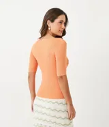 Blusa celeste de punto acanalado con cuello barco y mangas cortas.