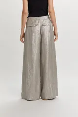 Pantalón ancho color gris metalizado, con pinzas delanteras, trabillas para cinto y cierre frontal con botón.