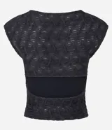 Blusa sin mangas de color negro, confeccionada en poliéster con textura en relieve, cuello redondo y corte al cuerpo.
