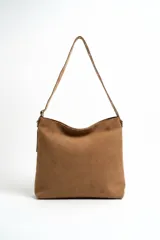 Bolso tipo hobo de gamuza color marrón, con diseño slouchy y correa larga ajustable para el hombro.