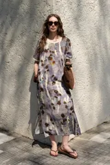 Vestido midi de manga corta, con diseño holgado, cuello redondo y estampado abstracto con detalles florales en tonos marrones y violetas.
