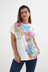 Remera blanca de algodón con estampado de flores y frutas en colores vibrantes.