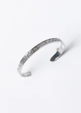 Pulsera esclava abierta de acero quirúrgico color plateado, con diseño de guarda griega.