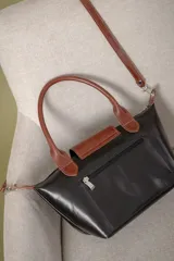 Cartera pequeña de mano tipo tote, confeccionada en gamuza color azul, con solapa y asas en cuero sintético con textura de reptil. Incluye cierre superior y correa larga ajustable y extraíble.