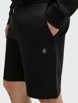 Short de corte regular confeccionado en tejido de algodón, con cintura elástica y cordón de ajuste. Presenta un diseño minimalista en color negro con un pequeño logo metálico en el lateral.
