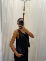 Musculosa negra con acabado satinado y sutil brillo, de corte holgado y diseño básico con breteles anchos.