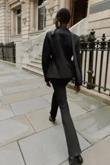 Leggings negros de tiro alto con costura marcada en el frente y bajo acampanado (flare). Cierre frontal con cremallera, botón interior y gancho.