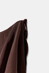 Falda midi de tiro alto, color blanco roto o crema, con múltiples capas de volantes asimétricos que le dan movimiento y textura.