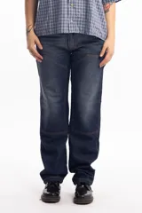 Pantalón de jean azul oscuro de corte recto, con refuerzos en las rodillas y bolsillos laterales. Diseño de estilo cargo con frente reforzado.