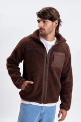 Campera de sherpa color marrón con cierre frontal completo, cuello alto y bolsillo en el pecho con cierre.