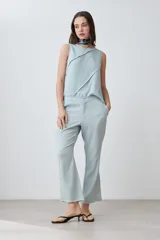 Blusa celeste de lino sin mangas con diseño asimétrico y efecto desflecado.
