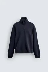 Sudadera de corte relajado confeccionada en tejido de algodón. Presenta cuello subido con cierre frontal de cremallera metálica, manga larga y acabados en rib en puños y bajo.