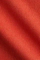 Top en punto fino tupido color naranja con cuello elevado corto y manga japonesa, con remate acanalado en el bajo.