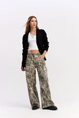 Saco de punto negro con escote en V y cierre frontal de botones. Presenta un tejido de punto con estructura marcada y calce relajado.