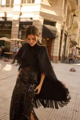Pollera larga de lentejuelas negras con diseño de tajo lateral profundo. Presenta una cintura alta con banda lisa y corte recto que se ajusta a la silueta.