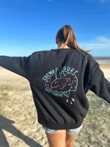 Buzo color crema de algodón con cuello redondo y mangas largas. Estampado en el frente con líneas horizontales de colores y una línea ondulada que simula un electrocardiograma.